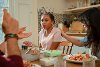 Young girl and two adults at dinner table eating 2